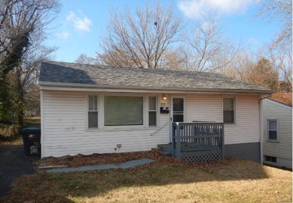 view of front of house with a deck and a front yard