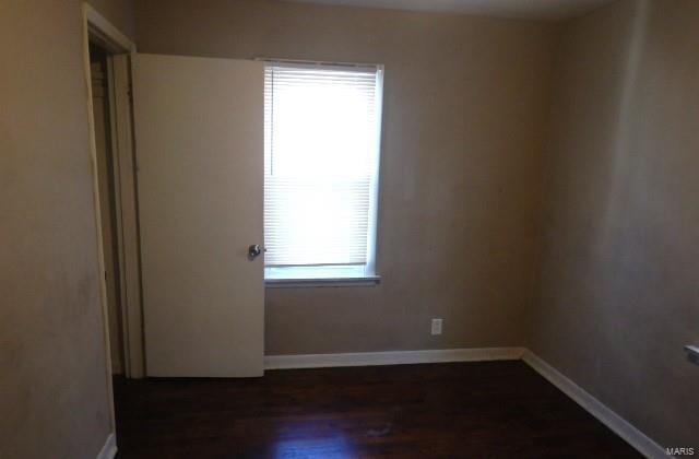 spare room with dark wood-type flooring