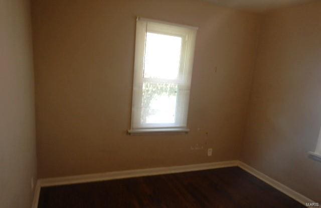 empty room with dark hardwood / wood-style floors