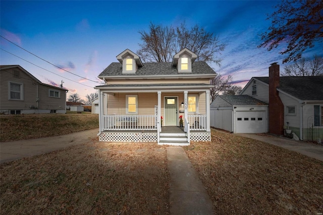 view of front of home with covered porch, a garage, and an outdoor structure