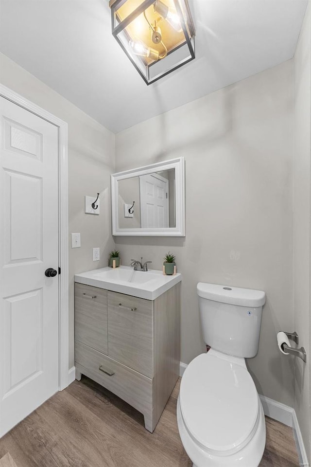 bathroom featuring toilet, vanity, and hardwood / wood-style flooring