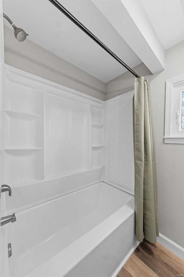 bathroom featuring wood-type flooring and shower / bathtub combination with curtain