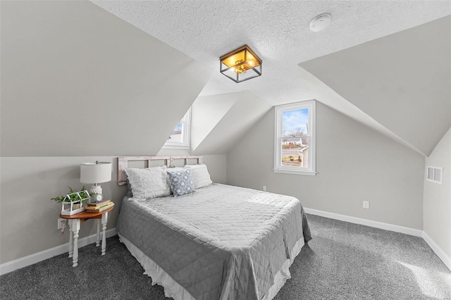 carpeted bedroom with a textured ceiling and vaulted ceiling