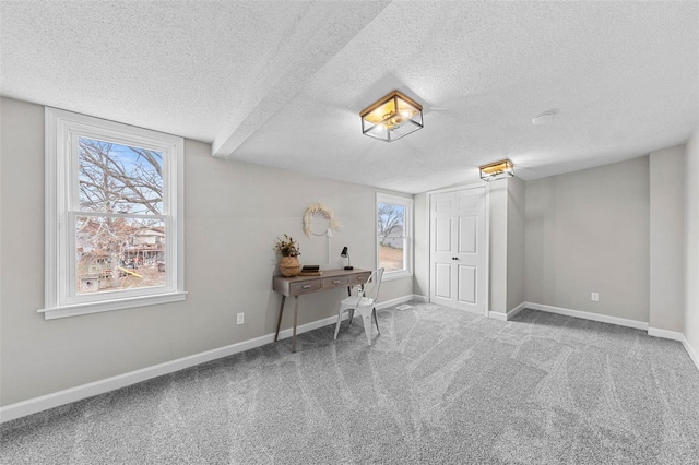 unfurnished office with carpet flooring and a textured ceiling