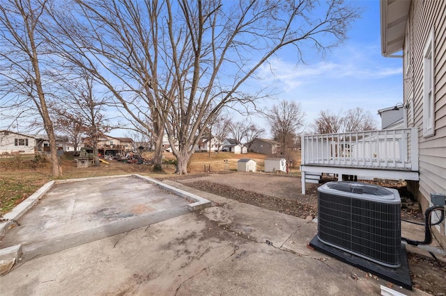 view of yard with cooling unit, a patio area, and a wooden deck