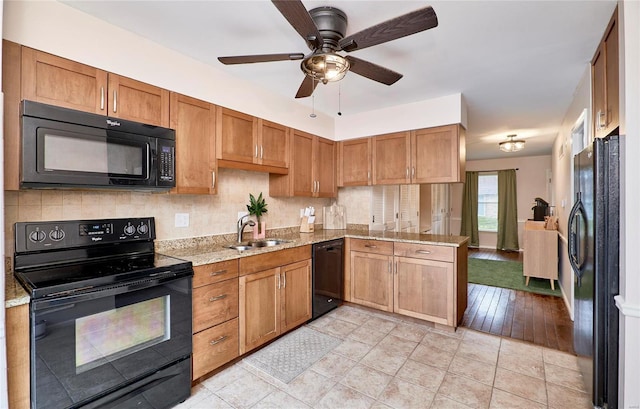 kitchen with black appliances, sink, ceiling fan, light tile patterned floors, and kitchen peninsula