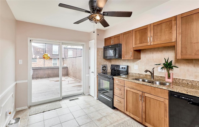 kitchen featuring backsplash, black appliances, sink, light tile patterned floors, and light stone counters