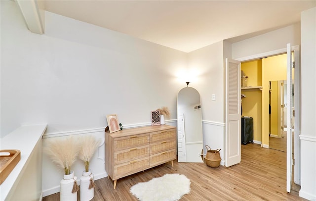 bedroom with a spacious closet, a closet, and light hardwood / wood-style floors