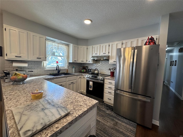 kitchen with appliances with stainless steel finishes, decorative backsplash, a textured ceiling, white cabinetry, and sink