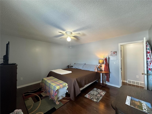 bedroom featuring ceiling fan, a textured ceiling, and dark hardwood / wood-style floors