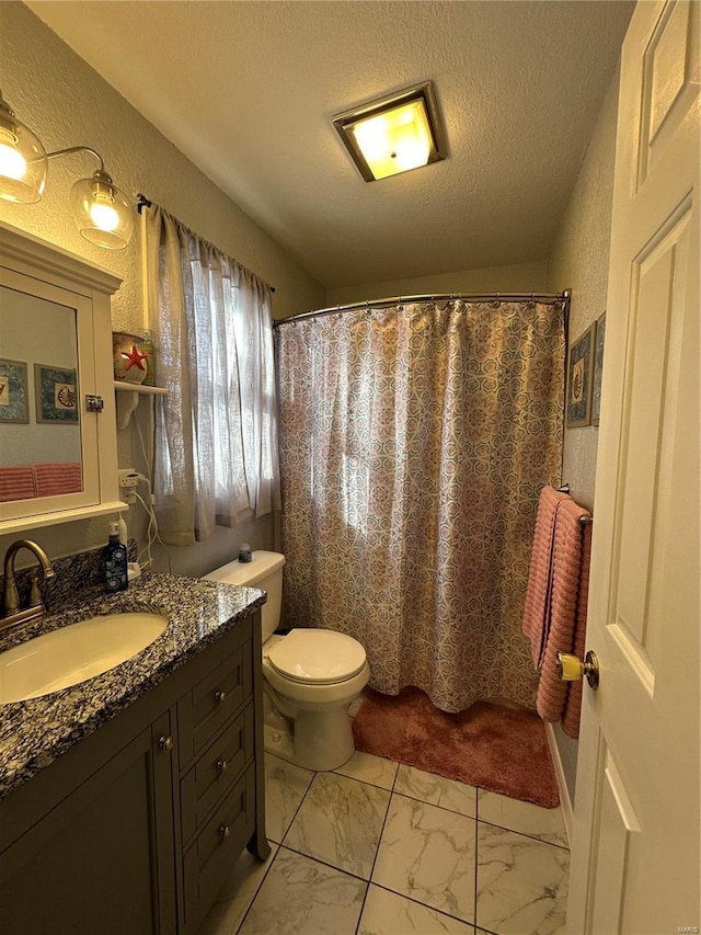 bathroom with a textured ceiling, a shower with curtain, vanity, and toilet