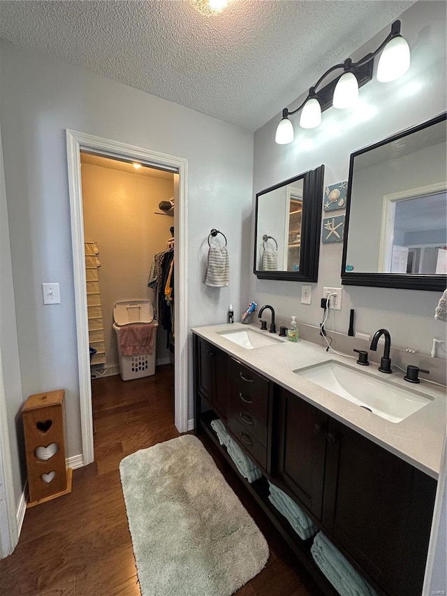 bathroom with hardwood / wood-style flooring, a textured ceiling, and vanity