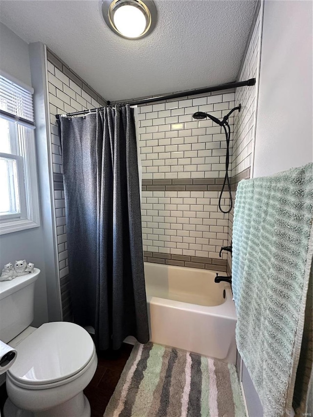 bathroom featuring toilet, a textured ceiling, and shower / tub combo