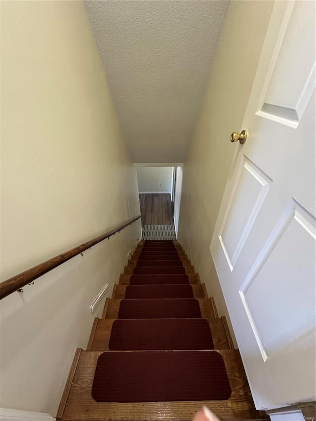 stairway with a textured ceiling