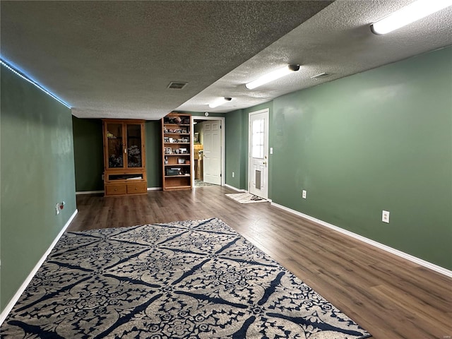 unfurnished living room featuring a textured ceiling and hardwood / wood-style floors