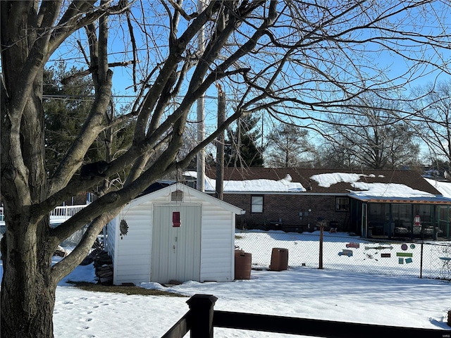 snowy yard with a storage shed