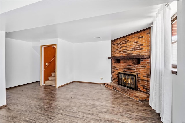 living room featuring hardwood / wood-style flooring and a brick fireplace