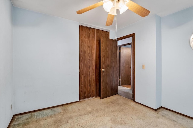 spare room with ceiling fan and light carpet