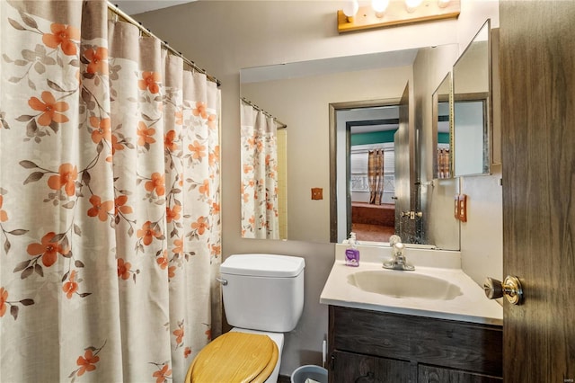 bathroom featuring a shower with shower curtain, vanity, and toilet