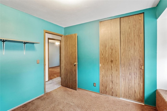 unfurnished bedroom featuring light carpet and a closet