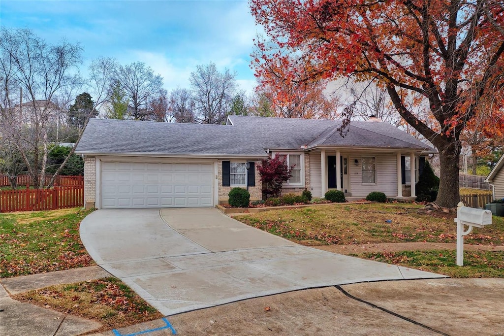 ranch-style home featuring a garage and a front lawn