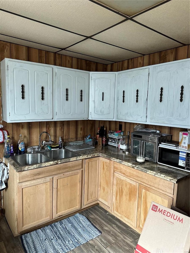 kitchen featuring dark hardwood / wood-style flooring, wood walls, and sink