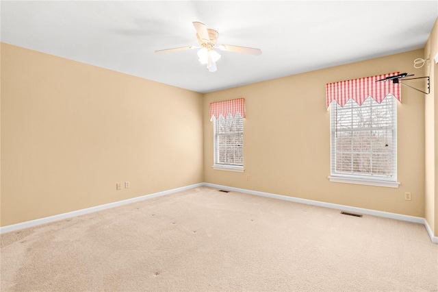 carpeted spare room featuring ceiling fan