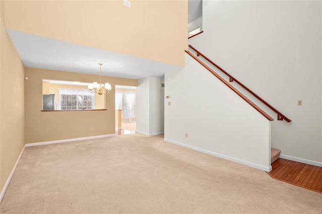 unfurnished living room featuring light carpet and an inviting chandelier