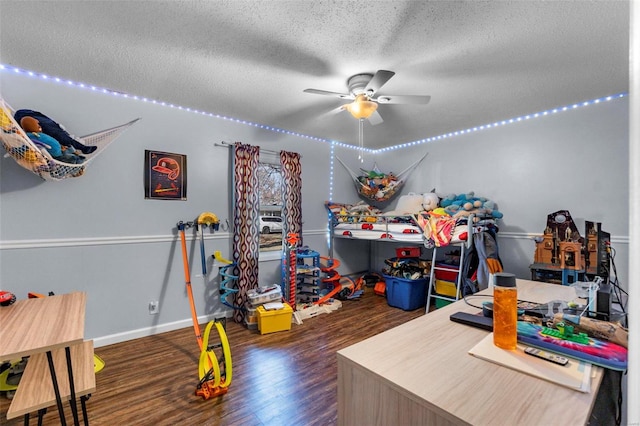 recreation room with a textured ceiling, dark hardwood / wood-style floors, and ceiling fan