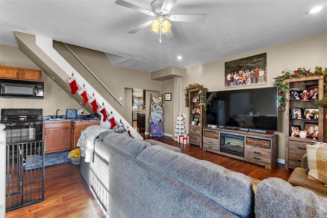 living room with ceiling fan, dark hardwood / wood-style flooring, and sink