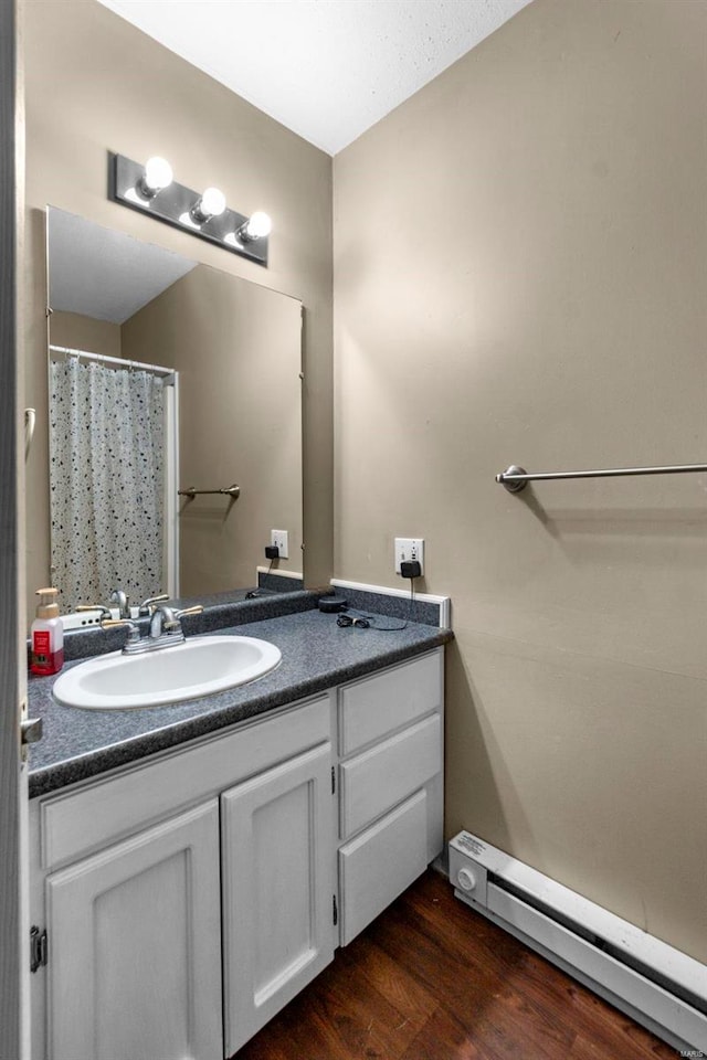 bathroom with baseboard heating, hardwood / wood-style floors, vanity, and a shower with shower curtain