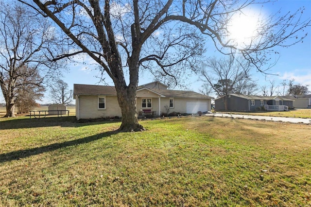 rear view of house featuring a yard and a garage