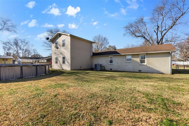 rear view of property featuring a yard and cooling unit