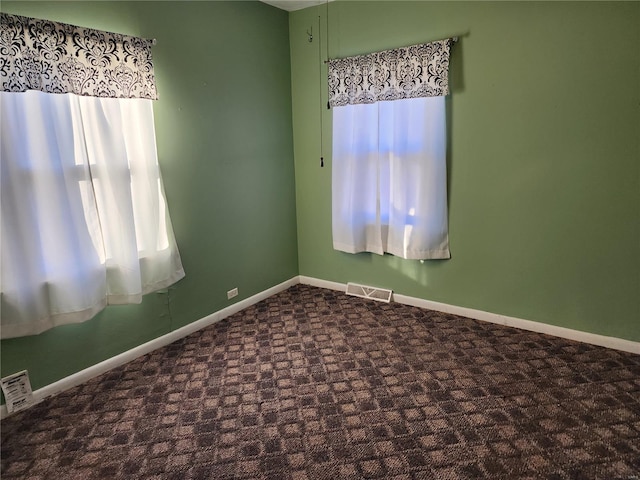 empty room featuring dark colored carpet