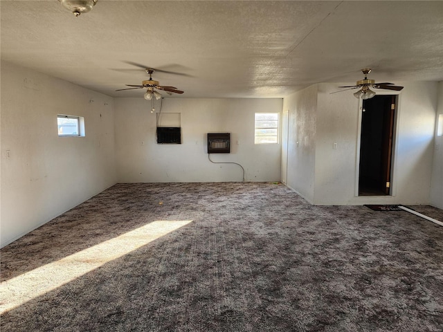 empty room with heating unit, carpet floors, and a textured ceiling