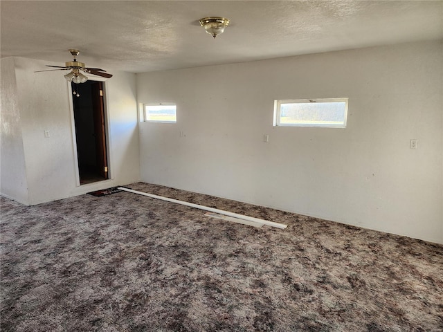 carpeted empty room featuring a textured ceiling