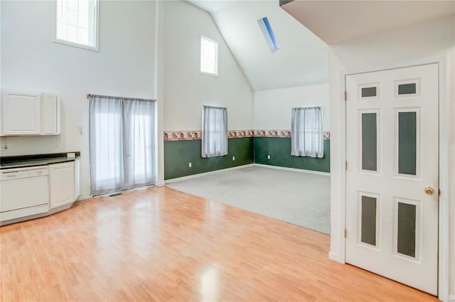 unfurnished living room featuring light carpet and high vaulted ceiling