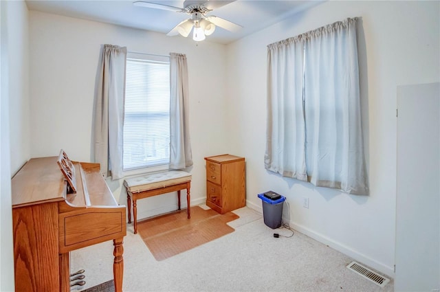 sitting room with light carpet, ceiling fan, and a healthy amount of sunlight