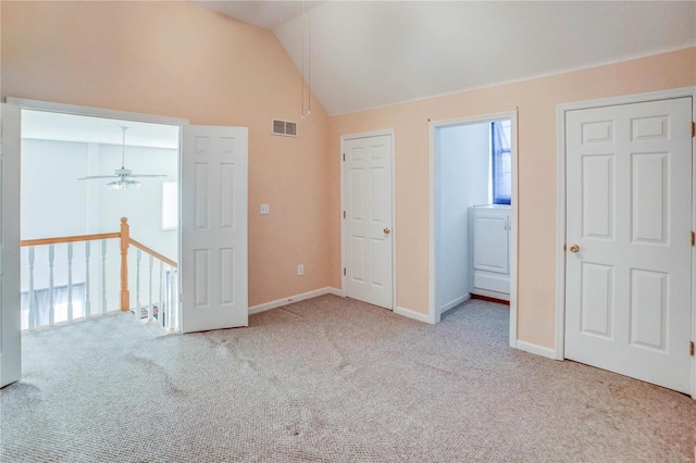 interior space with light carpet and vaulted ceiling