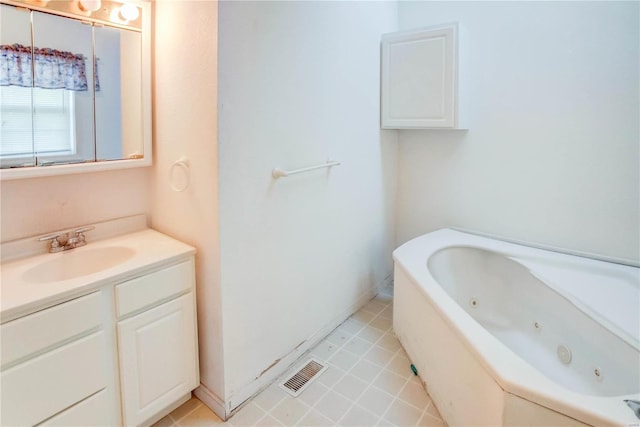 bathroom featuring tile patterned floors, vanity, and a bath