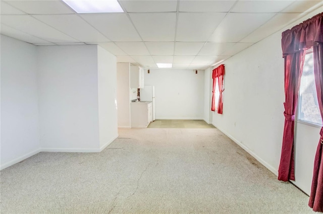 spare room with a drop ceiling and light carpet