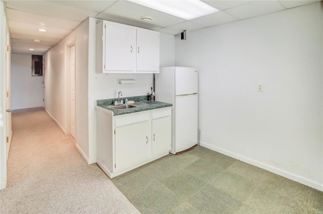 kitchen featuring white cabinetry, a drop ceiling, light colored carpet, and white refrigerator