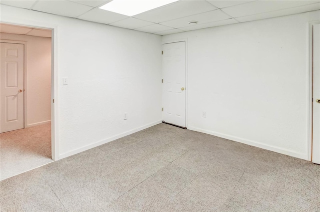 empty room featuring carpet and a paneled ceiling