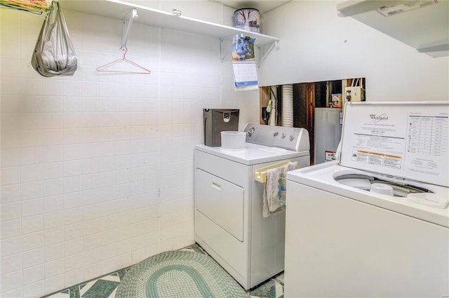 clothes washing area featuring gas water heater and independent washer and dryer