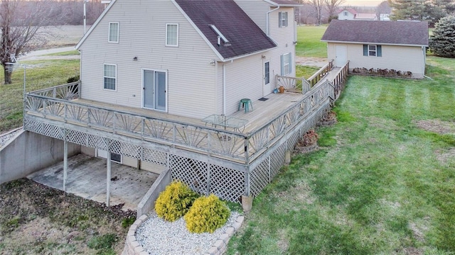 back of property with a yard, an outdoor structure, and a wooden deck