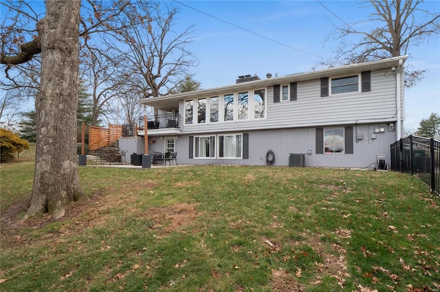 back of property with a patio, a balcony, central AC unit, and a lawn