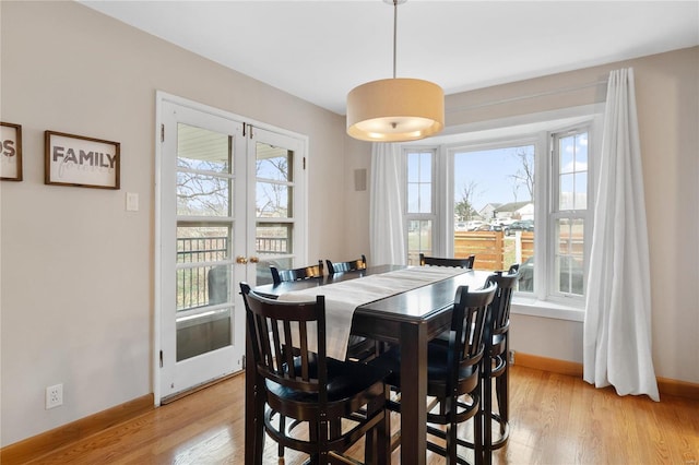 dining space with a wealth of natural light, light hardwood / wood-style flooring, and french doors