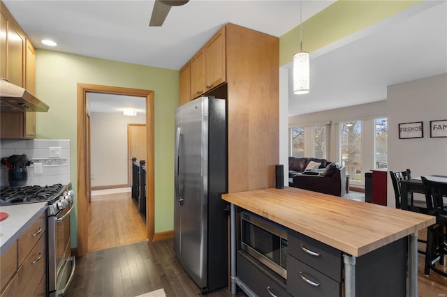 kitchen with backsplash, hanging light fixtures, butcher block countertops, dark hardwood / wood-style flooring, and stainless steel appliances