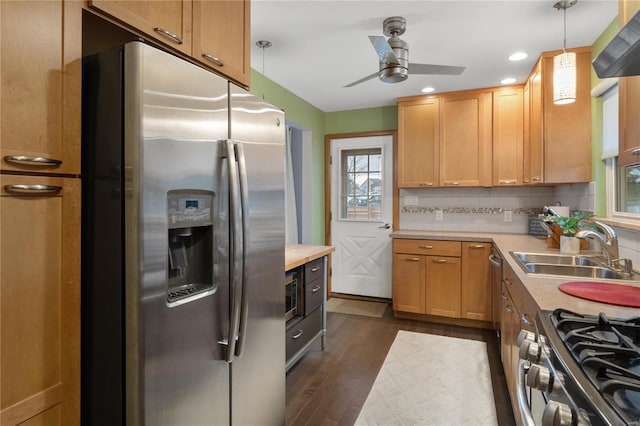 kitchen with dark wood-type flooring, sink, decorative backsplash, appliances with stainless steel finishes, and decorative light fixtures