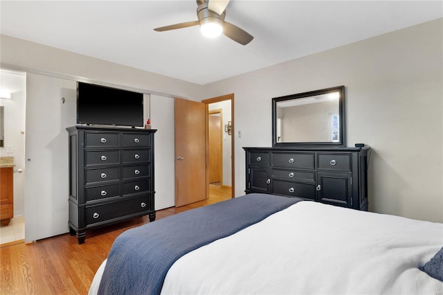 bedroom featuring ensuite bathroom, ceiling fan, and light wood-type flooring